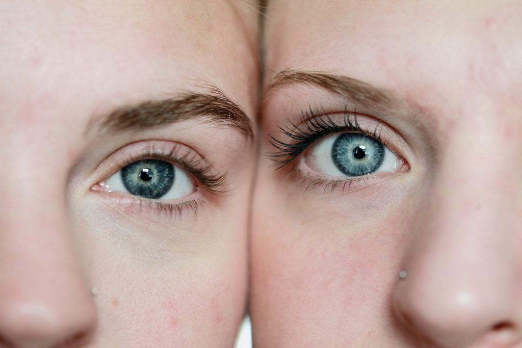 Nahaufnahme von zwei sich berührenden Gesichtern mit blauen Augen